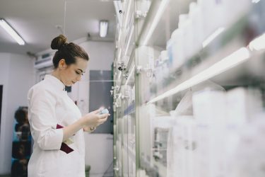 Woman Pharmacist Checking Medicine In Pharmacy